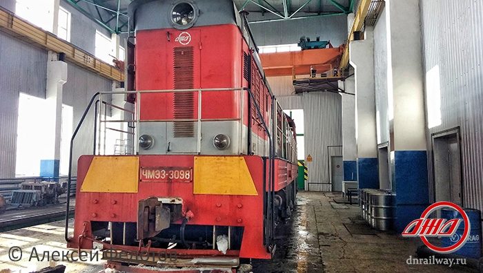 Тепловоз стоит в депо Донецкая Железная дорога красно серый поезд сине серые стены депо
